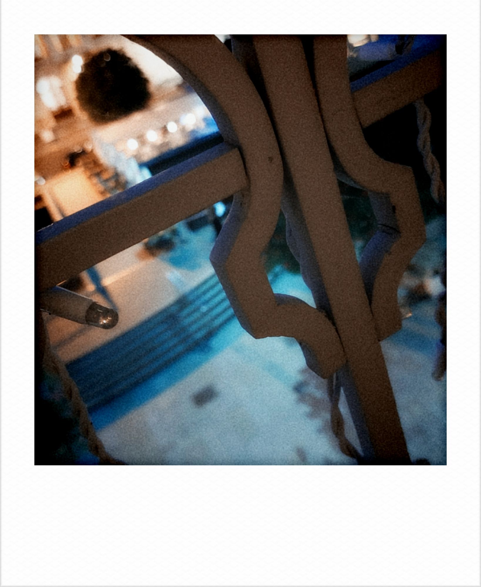 Looking down onto an empty street through a balcony railing.