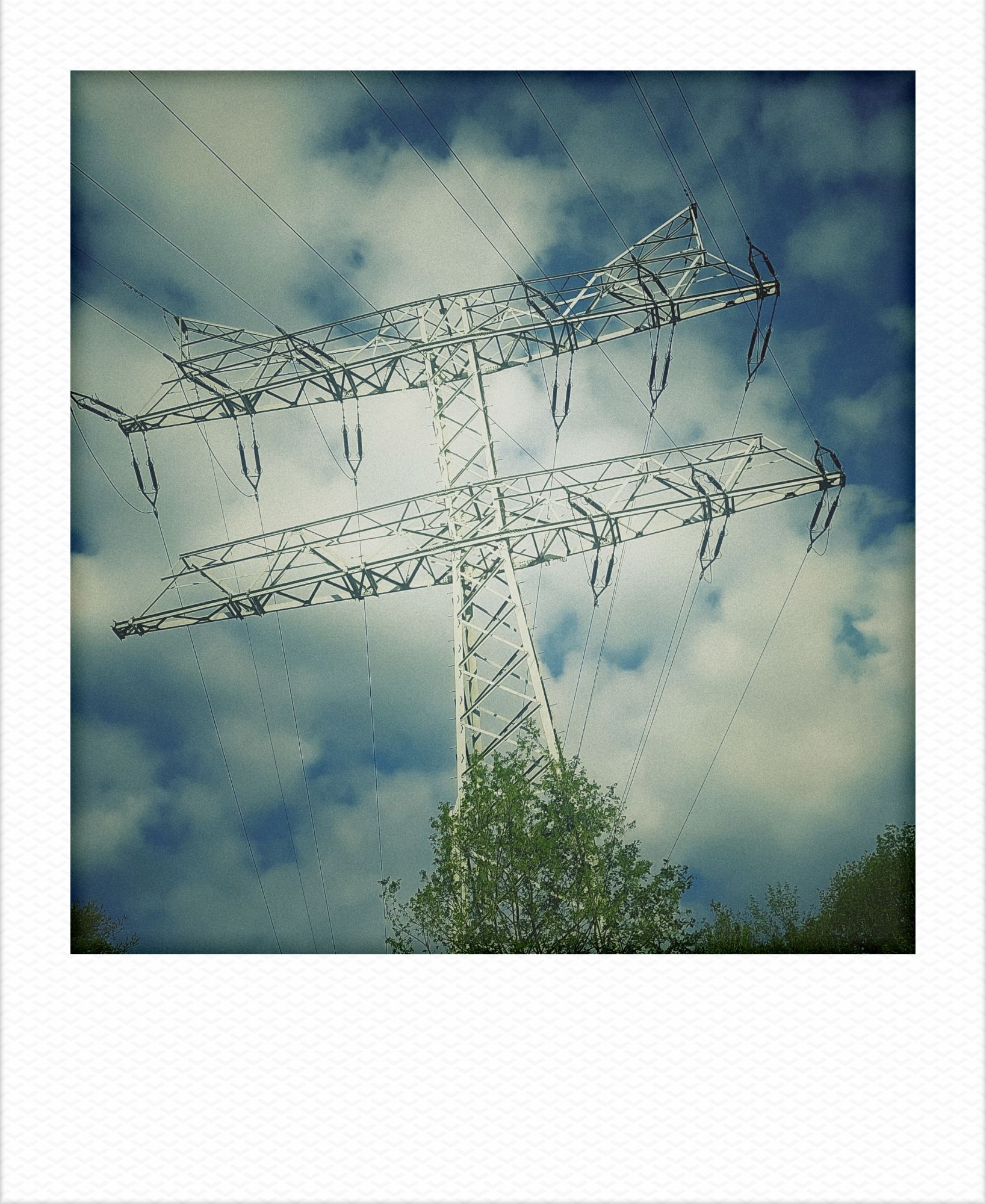 Powerlines in front of cloudy blue sky.
