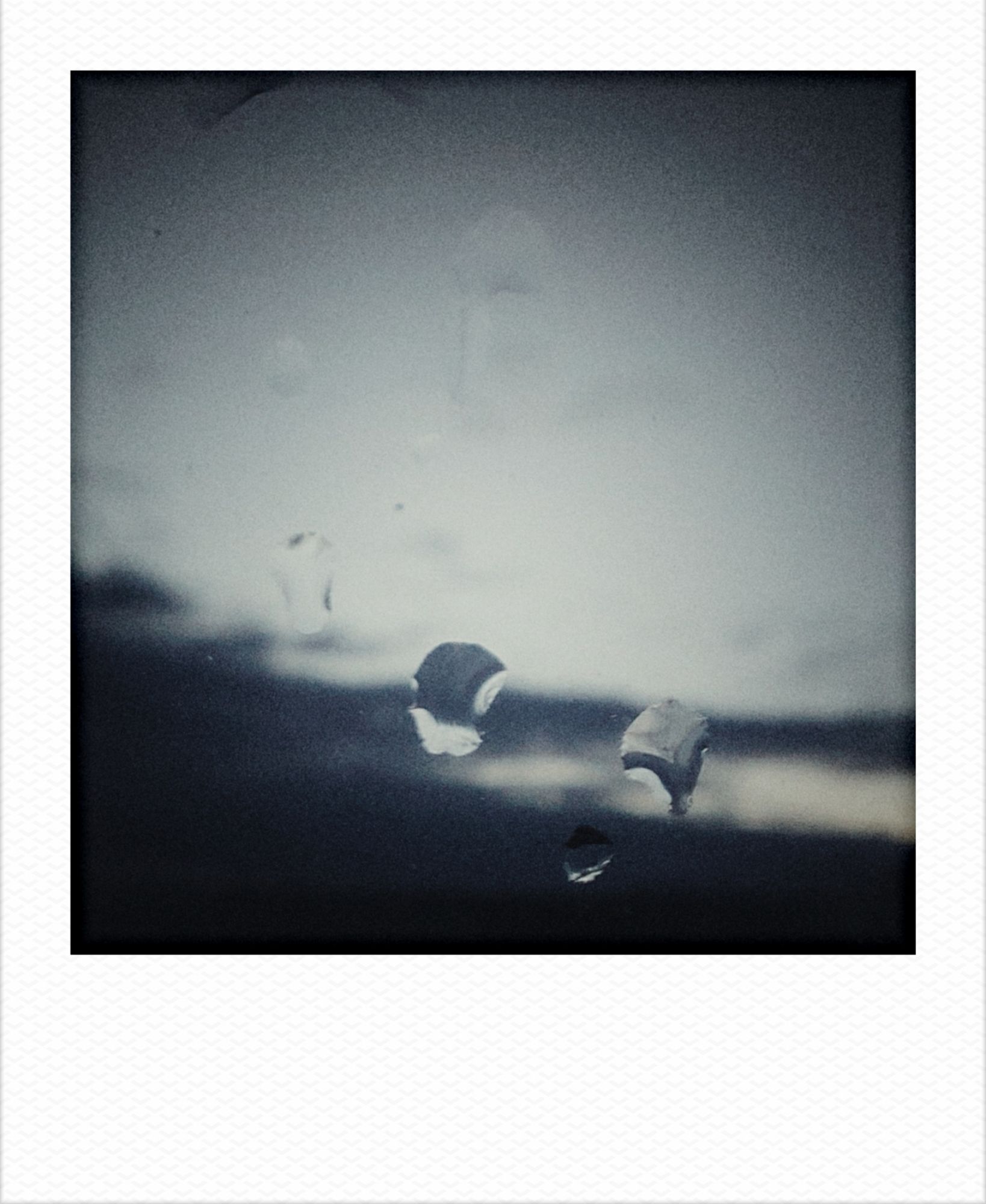 Clouds tearing up for sunrise. Raindrops on a windowpane in front.