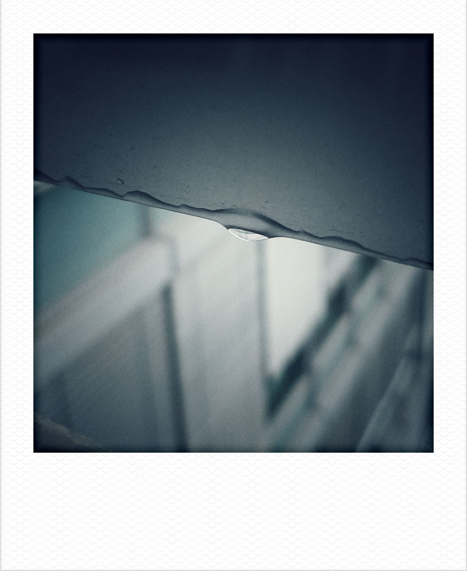 Raindrop on a windowblind. Facade of an office building in the back.