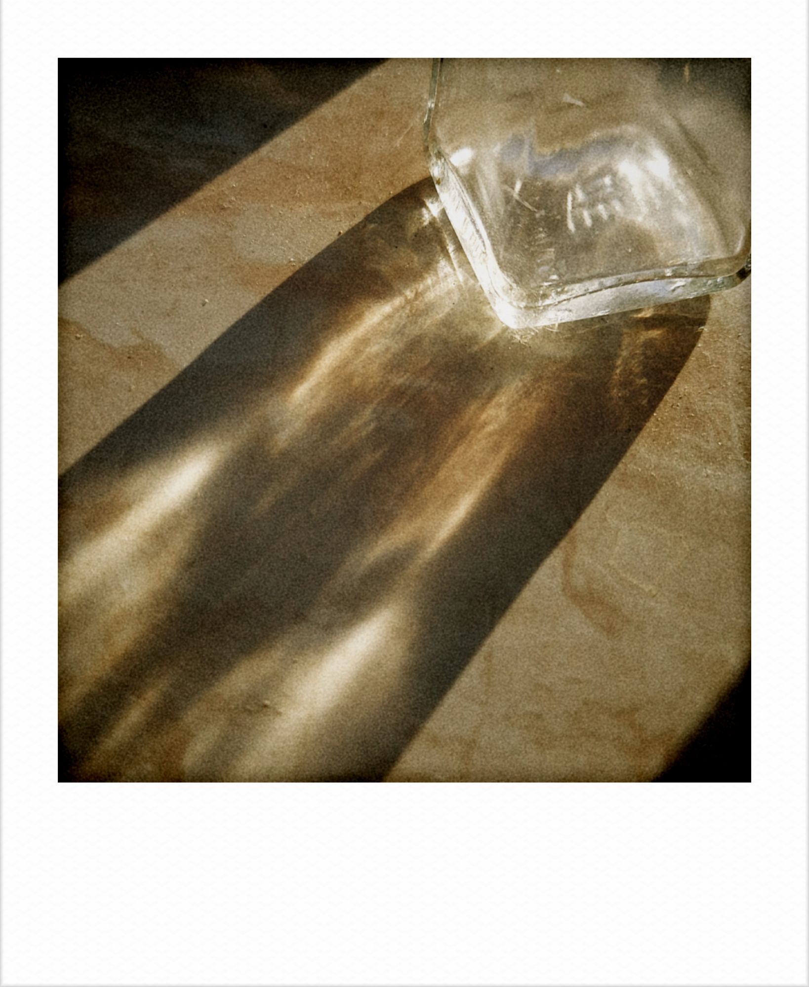 Early sunlight falling through a glass vessel on a windowsill.