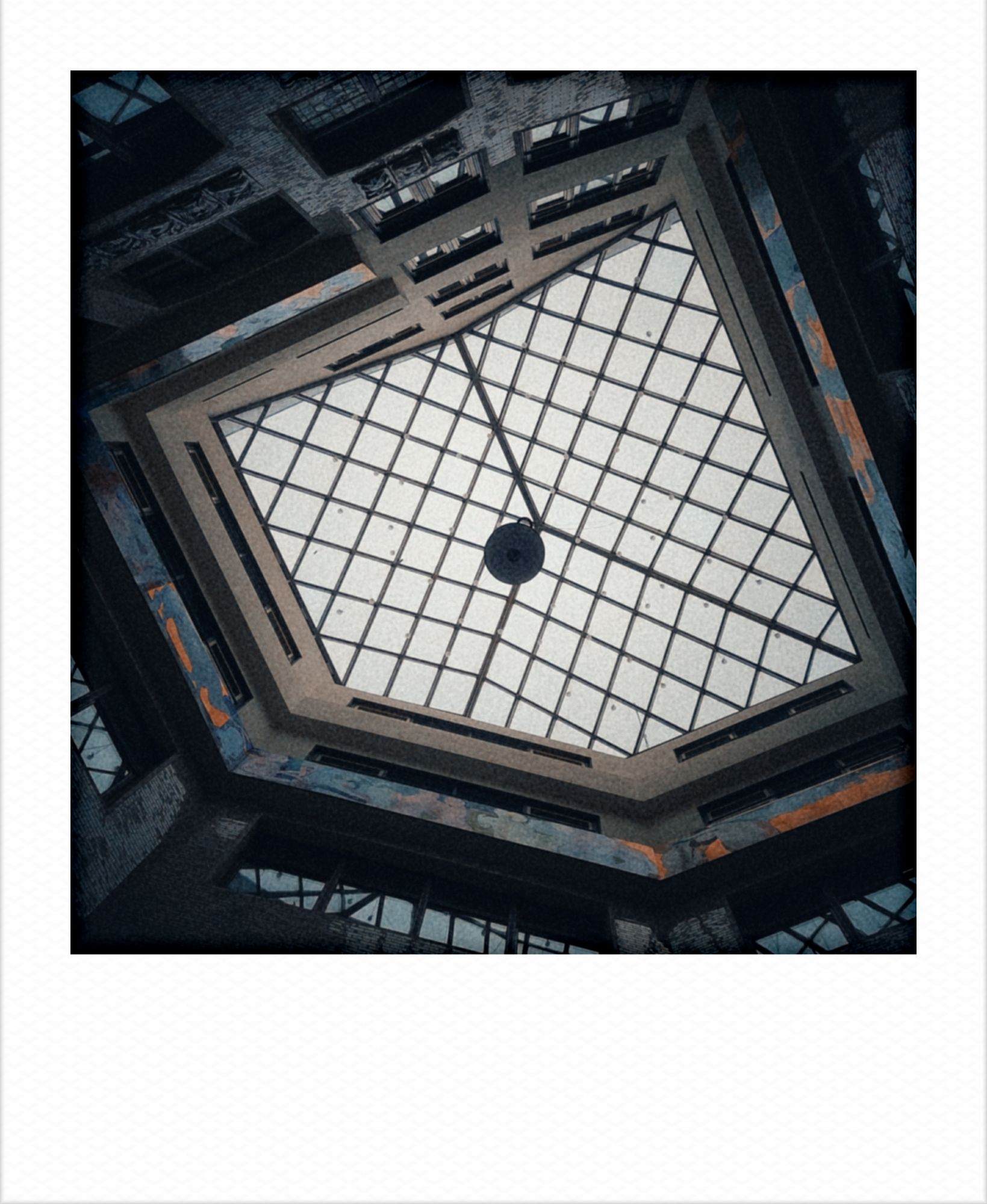 Looking up in an old backyard. A grid in front of the sky. Windows. Facades.