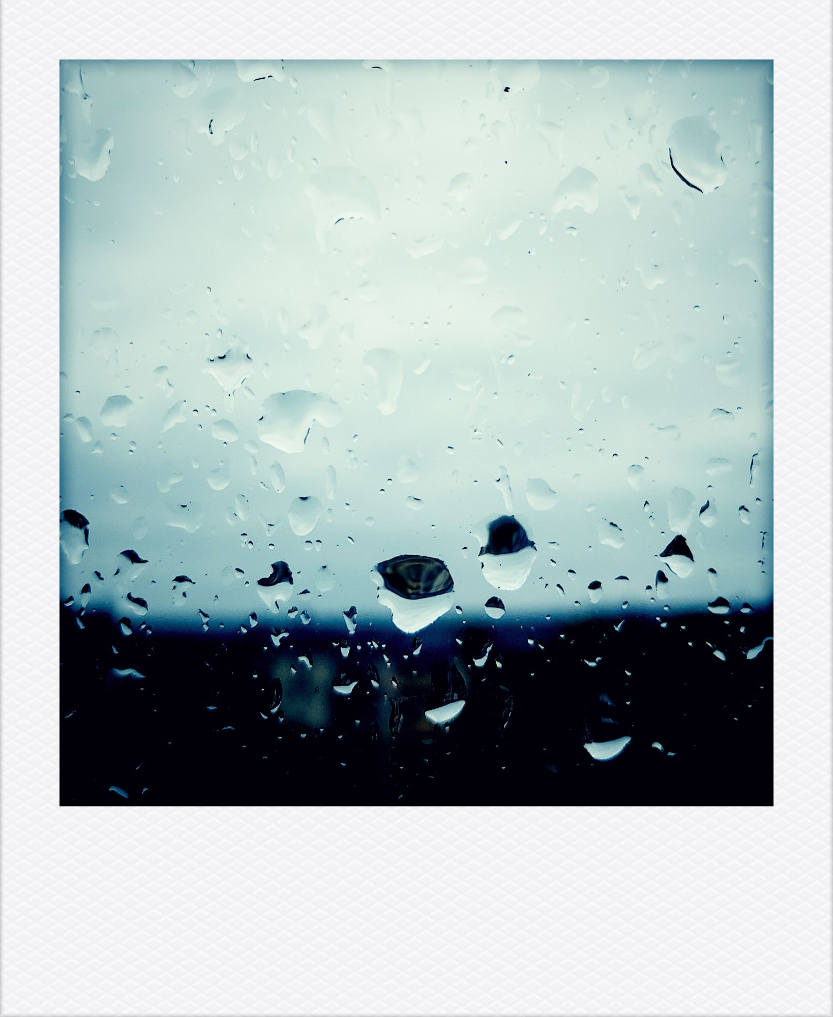 A city line blurred behind rainy windowpane.